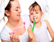 Мама учит ребенка чистить зубы