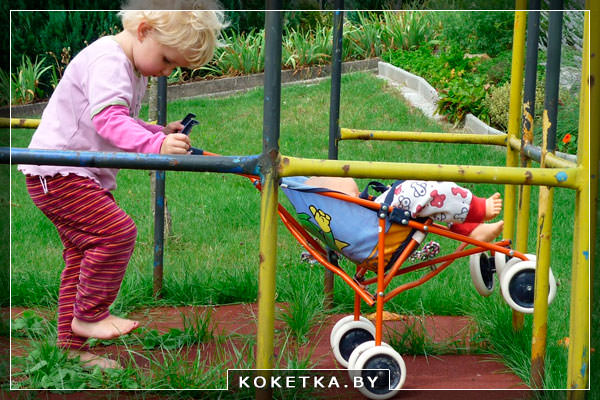 Ребёнок играет с детской коляской