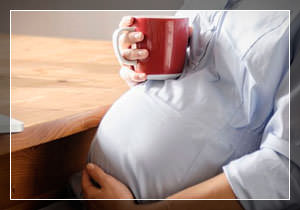 Беременная девушка пьет кофе