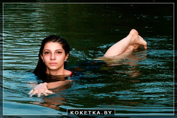 Беременная девушка купается в водоёме 