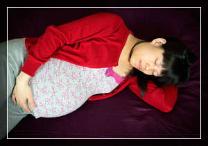 Спящая беременная девушка