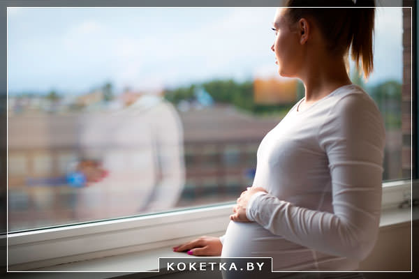 Беременная девушка в депрессии у окна