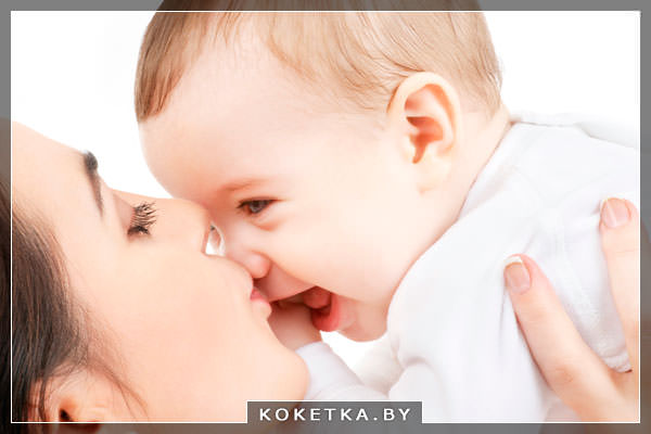 Мама целует малыша у которого начали прорезаться зубки