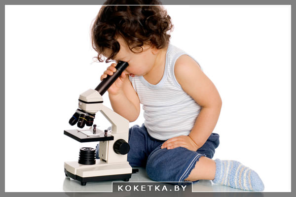 Маленький ребенок смотрит в микроскоп 