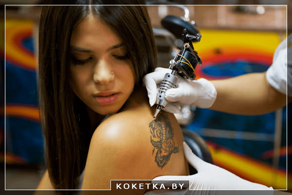 Девушке наносят татуировку на тело