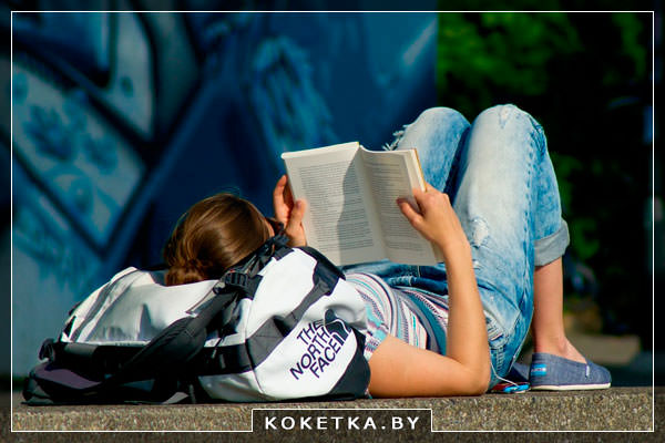 Девушка читает книгу на улице