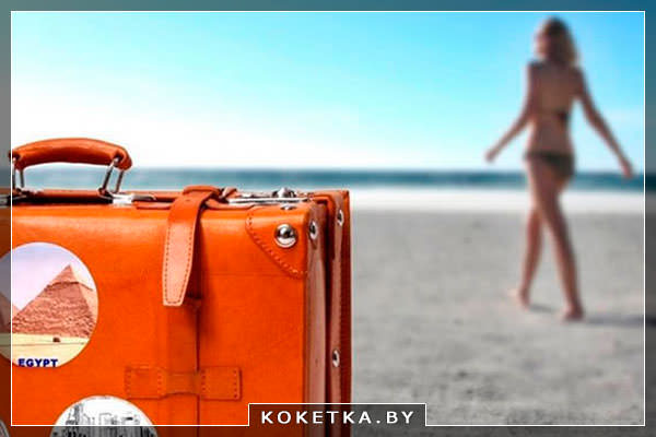 Девушка с чемоданом в купальнике на берегу моря