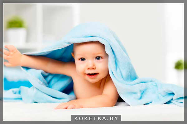 Ребенок нежится в мягком махровом полотенце 